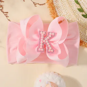 Bandeau rose pour bébé avec un grand nœud papillon et une lettre K perlée décorative