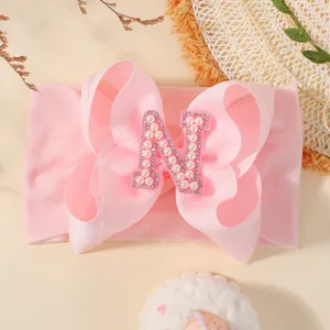Bandeau bébé rose doux avec grand nœud décoré d'une lettre N en perles de luxe