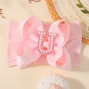 Bandeau rose avec nœud pour bébé orné d'une lettre U décorative sertie de perles