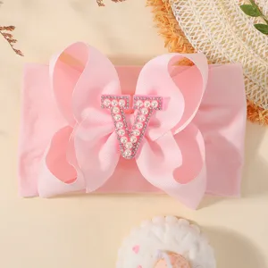 Bandeau bébé rose avec grand nœud et élégante initiale V en perles et strass brillant