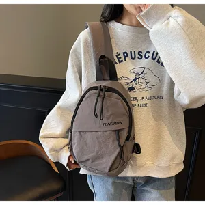 Nahaufnahme einer grauen Streetstyle-Unisex-Umhängetasche, die über einem Sweatshirt getragen wird