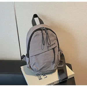 Detailansicht einer grauen Streetstyle-Brusttasche mit strukturiertem Stoff und Logo