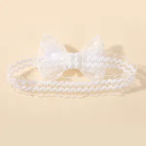 Detailweergave van een elegante witte kanten en tule hoofdband met strik voor pasgeboren baby's