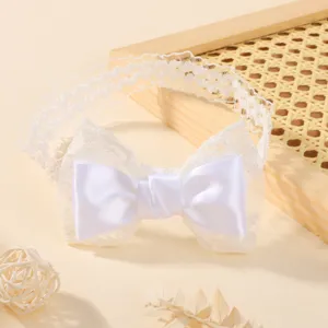 Gedetailleerd overzicht van witte elastische kanten babyhoofdband met satijnen strik