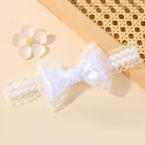 Elegante witte kanten babyhaarband met satijnen strik en decoratieve bloemen.