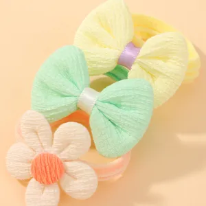 Gros plan détaillé montrant la texture tricotée de chouchous à nœuds et fleurs pour filles