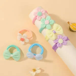 Vue détaillée d'élastiques à cheveux tricotés pour enfants avec fleurs et nœuds.