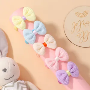 Vue détaillée de chouchous colorés avec nœuds tricotés pour filles sur support rose