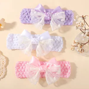 Close-up of three colorful hollow baby headbands with large lace and satin bows