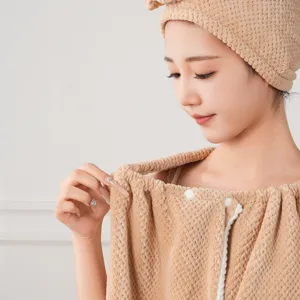 Close-up detail of soft coral fleece wearable bath towel and matching dry hair cap.