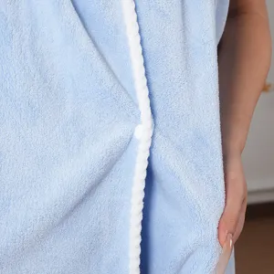 Coral fleece wearable bath towel detail, showing soft plush fabric texture and white trim.