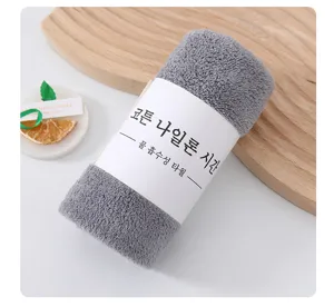 Grijs koraalfleece handdoek met papieren wikkel, absorberend en sneldrogend voor dagelijks gebruik.