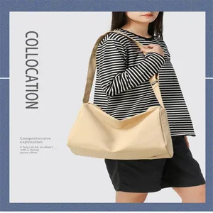 Minimalistische beige Umhängetasche gestylt mit gestreiftem Shirt für den Alltag
