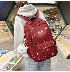 Large capacity student backpack with cute star prints and cat pendant for school girls.