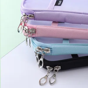 Close-up detail of multi-layer nylon mesh zipper pencil case with metal ring pulls.