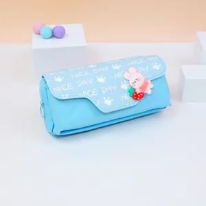 Vista dettagliata dell'astuccio azzurro con un simpatico coniglio e charm a fragola.