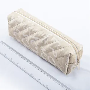 Quilted beige pencil pouch with large capacity, durable zipper closure and neat stitching.