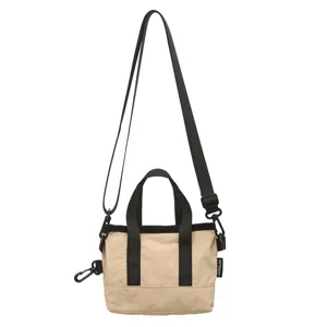 Small beige and black color-block crossbody bag with durable nylon straps and side tag