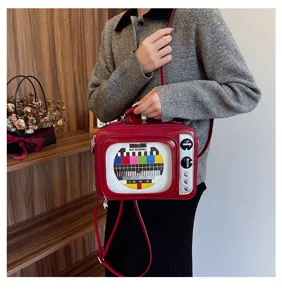 Retro TV-shaped red PU leather bag featuring a NO SIGNAL screen pattern and silver knobs.