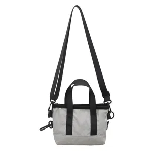 Detail view of a compact contrast color tote bag with black webbing straps