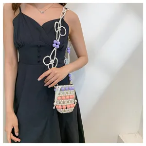 Detailansicht einer Mini-Perlen-Eimertasche mit bunten Akzenten auf einem schwarzen Kleid.