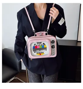 Detailed view of a pink vintage television-shaped PU leather crossbody bag worn by a model
