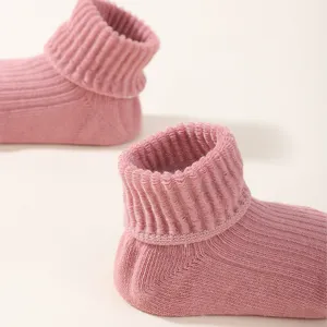 Close-up detail of soft pink ribbed knit baby socks featuring comfortable elastic cuffs.