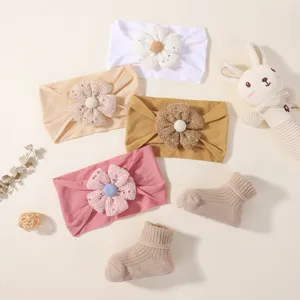 Detailed view of soft baby floral headband set and ribbed socks in warm earth tones.