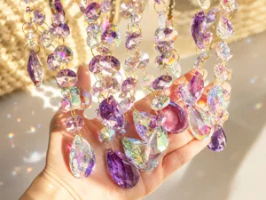 Primo piano di prismi acchiappasole in cristallo viola e AB che riflettono la luce