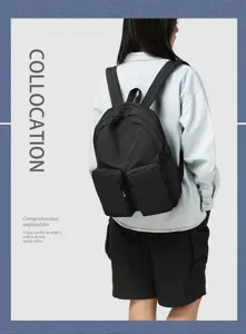 Back view of a black high-capacity backpack with dual front pockets on a model