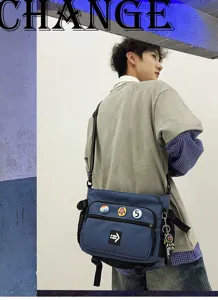 Detailed view of blue Korean style messenger bag with decorative patches and keychain