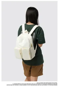 Back view of a model wearing a large capacity white backpack with dual pockets