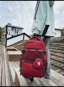 Großer burgunderroter Schulrucksack mit Schlägern und Tasche im Freien