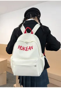 Sac à dos scolaire blanc léger avec broderie HDKEAN rouge porté par un mannequin