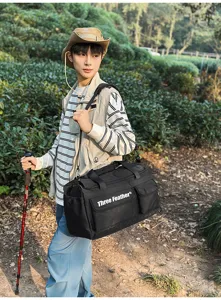 Große schwarze Outdoor-Reisetasche, die von einem Wanderer im Wald verwendet wird.