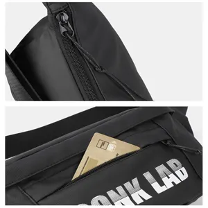 Detalle de cerca de bolso de pecho negro estilo callejero con logo UNK LAB y bolsillo.