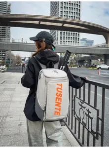 Großer grauer Outdoor-Sportrucksack mit orangefarbenem TUSENTE-Schriftzug im Stadtbild