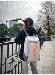 Detailansicht eines grauen Sportrucksacks mit großem Fassungsvermögen und orangefarbener Schrift