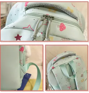 Detail view of mint green backpack with cute star and mushroom print, showing double zippers and straps.