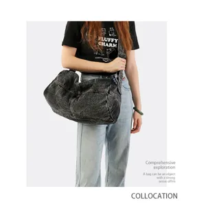 Detailed view of a large washed denim crossbody duffle bag worn by a fashion model.