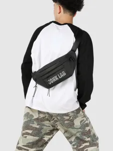 Bolso de pecho negro estilo street con estampado CONK LAB llevado por un modelo