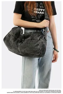 Detailed view of large capacity washed denim messenger bag styled on a model's shoulder.