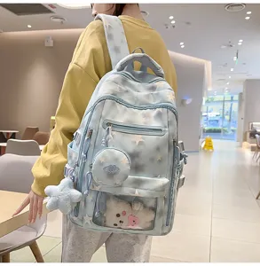 Zaino blu per studenti con stelle bianche indossato in un ambiente interno luminoso