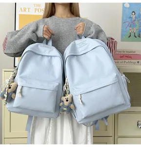 Mannequin tenant deux sacs à dos bleu clair de grande capacité avec breloque ours