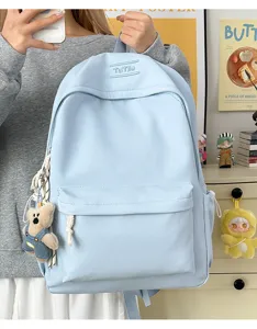 Détail du sac à dos d'étudiant bleu clair couleur bonbon avec pendentif ours mignon