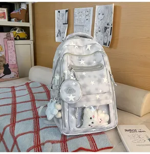 Dettaglio dello zaino grigio con motivi a stelle e adorabili ciondoli in peluche
