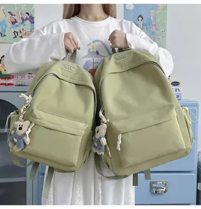 Vue détaillée de deux sacs à dos vert clair avec d'adorables porte-clés oursons