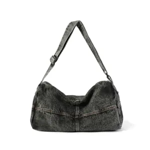 Washed denim messenger bag with distressed finish and adjustable shoulder strap