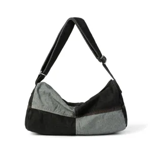 Detail view of washed patchwork denim shoulder bag with contrast orange stitching