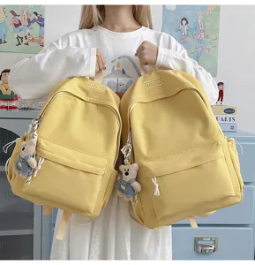 Comparaison de sacs à dos jaunes pour étudiants avec de jolis charms d'ours.